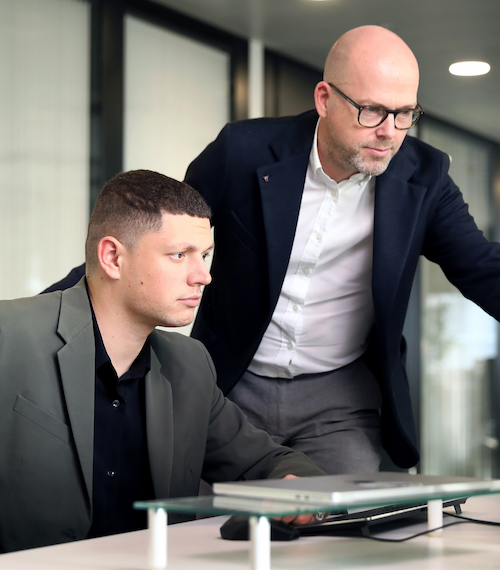 Two Strike employees listen attentively to each other during an experience-sharing meeting.