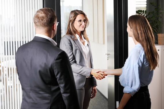 A man and a woman, clients of Strike, listen attentively to their financial advisor during an appointment to analyze their financial capacity.