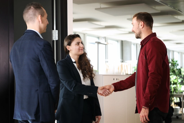 A man and a woman, clients of Strike, listen attentively to their financial advisor during an appointment to analyze their financial capacity.